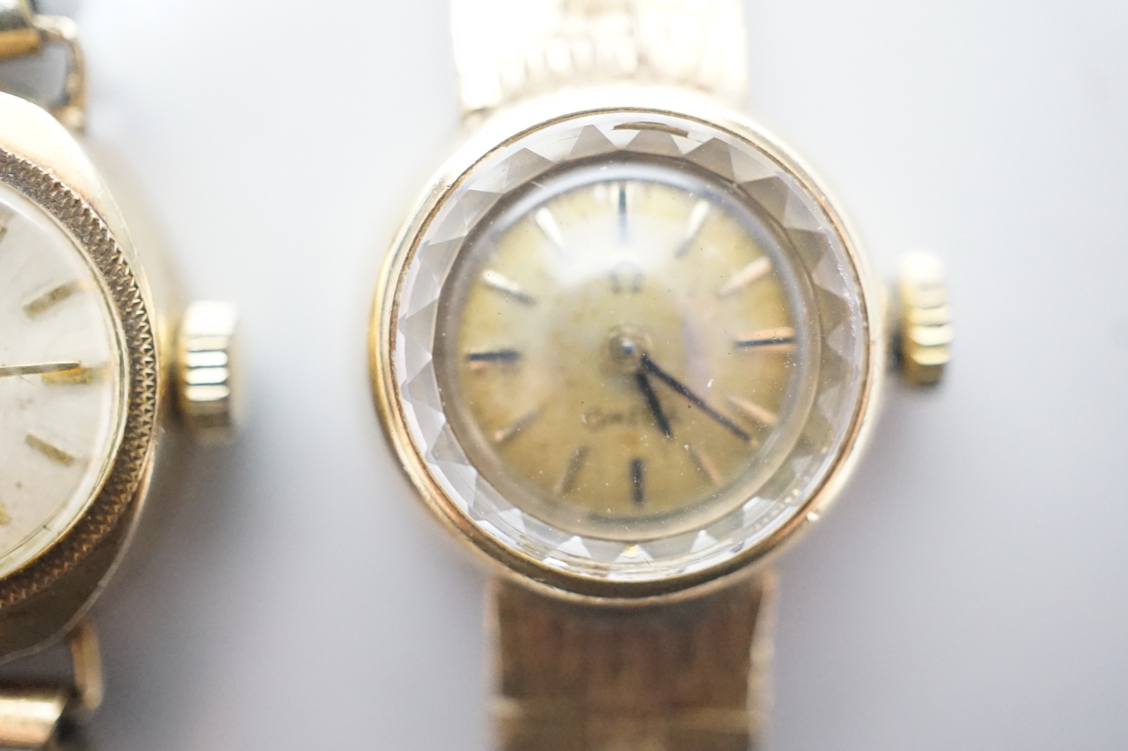 A lady's 9ct gold Omega manual wind wrist watch, on associated 9ct gold bracelet, overall 15.8cm, gross weight 17.8 grams and one other lady's 9ct gold watch on a gold plated bracelet.